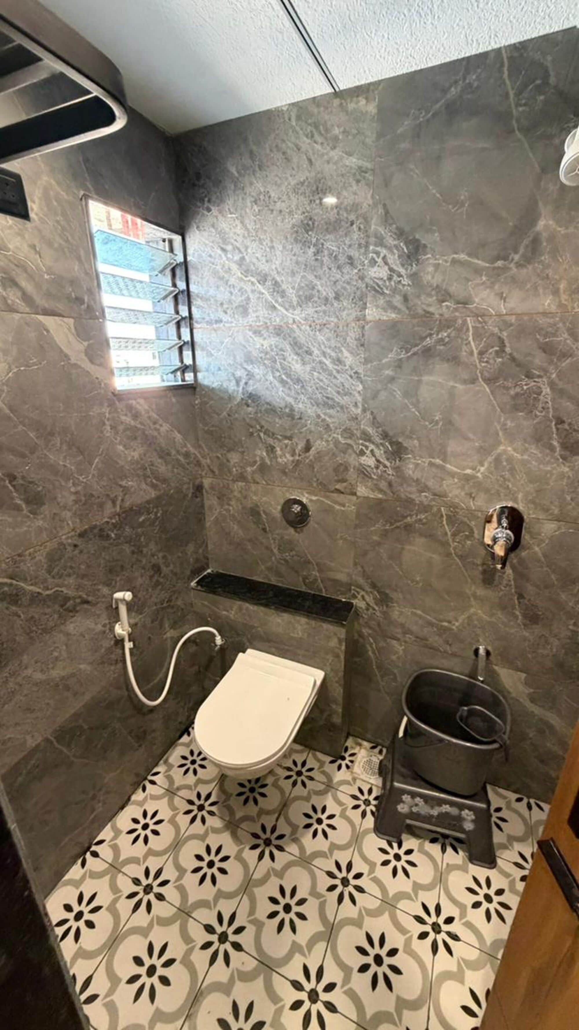 Et badeværelse med toilet, bruser og håndvask.