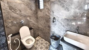 A bathroom with a toilet, bidet, and bathtub. - Hotel Ishant (Dwarka)