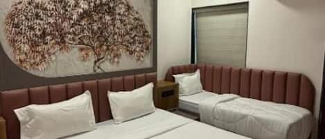 A bedroom with a large bed, a smaller bed, a ceiling fan, and a wall-mounted air conditioner.