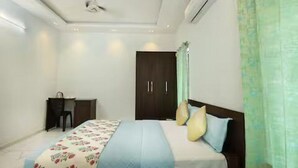 A bedroom with a bed, a desk, and a wardrobe. - Alleppey Breeze by 8MH - Luxury Backwater Villa (Mararikulam)