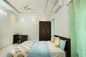 A bedroom with a bed, a desk, and a wardrobe. - Alleppey Breeze by 8MH - Luxury Backwater Villa (Mararikulam)