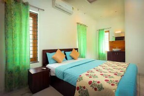 A bedroom with a bed, nightstand, and a window with curtains. - Alleppey Breeze by 8MH - Luxury Backwater Villa (Mararikulam)