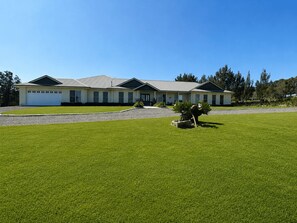 A two-story house with a garage, a well-maintained lawn, and a small garden area.