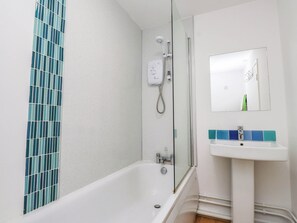 A bathroom with a bathtub, a shower, and a sink with a mirror above it. - Cecily's Retreat (Criccieth)