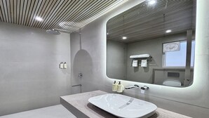 A modern bathroom with a large mirror, a bathtub, and a shower. - Signum Tathastu Boutique Hotel- Haridwar (Haridwar)