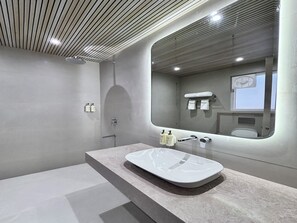 Ein modernes Badezimmer mit großem Spiegel, einer Badewanne und einer Dusche.