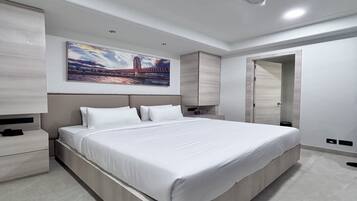 Un dormitorio moderno con una cama grande, una mesita de noche, un armario y un cuadro en la pared.