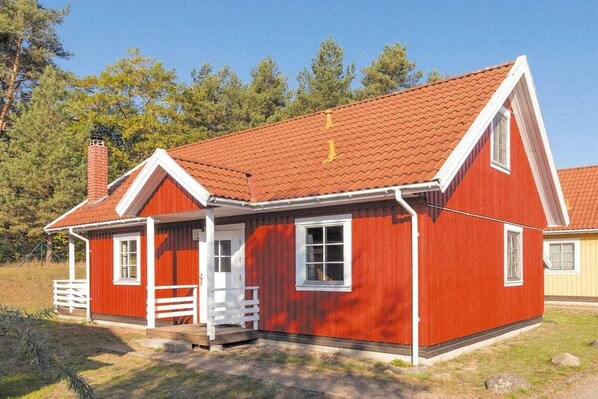 A red wooden house with a white porch and a chimney. - Swedish House Red Water Lily (Userin)