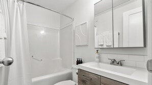Et moderne badeværelse med badekar, toilet og vaskebord.