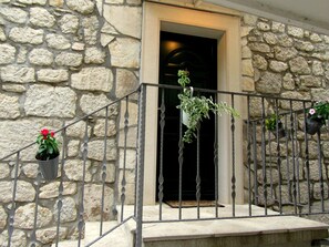 A stone building with a metal staircase and potted plants. - HAUS DALMATIEN-TUCEPI (MAKARSKA)