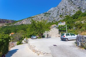 Ein Steinhaus mit befestigter Auffahrt und geparkten Autos.