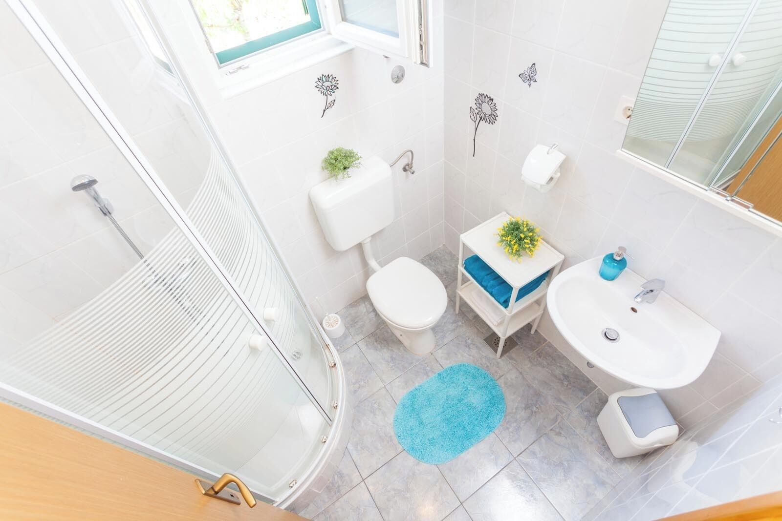 Un bagno con doccia, toilette e lavandino.