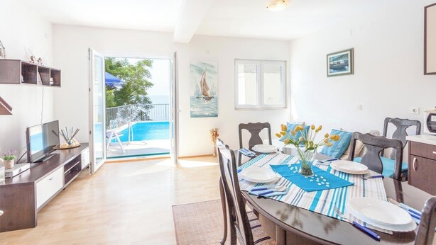 A dining area with a view of the sea, a pool, and a balcony. - HAUS DALMATIEN-TUCEPI (MAKARSKA)