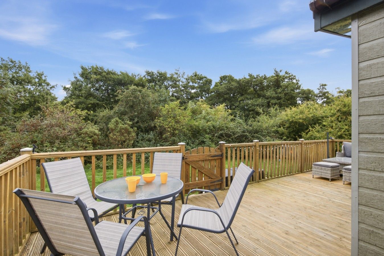 Private deck with outdoor dining furniture overlooking surrounding greenery