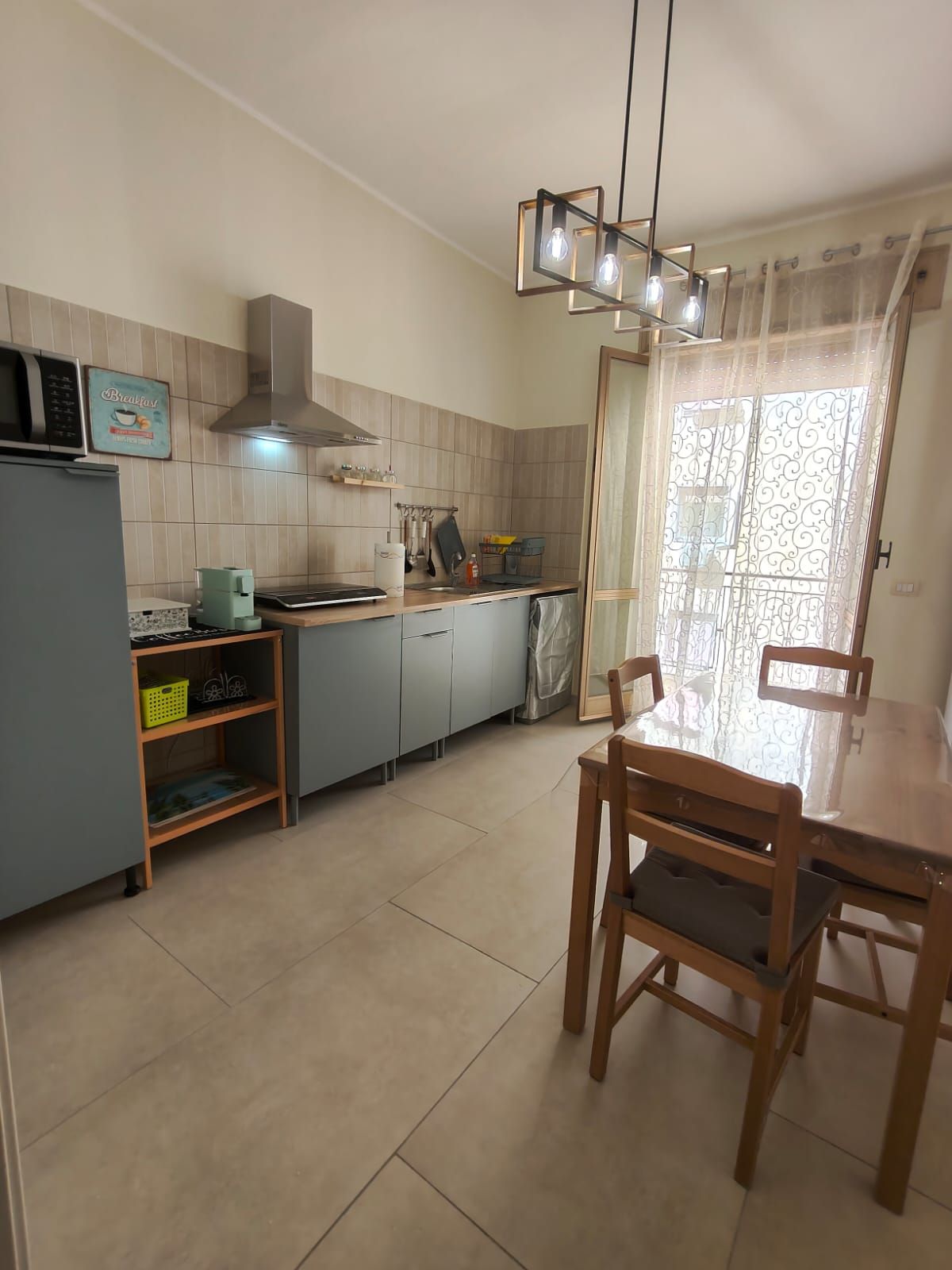 Una cucina con tavolo e sedie, un frigorifero, un forno a microonde e una macchina del caffè.