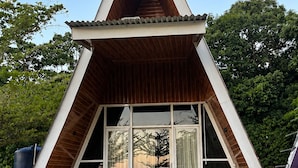 Ein dreieckiges Gebäude mit geneigtem Dach und großen Fenstern.