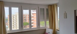 Ein Zimmer mit einem großen Fenster, einer Heizung und einem an der Wand befestigten Schild.