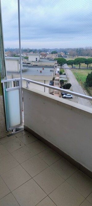 Ein Balkon mit Blick auf ein Wohngebiet, darunter Häuser und eine Straße.