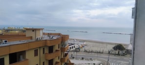 A coastal view with buildings, a beach, and a stop sign. - Vrbo Property (Lido di Pomposa)