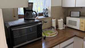 A kitchen with a microwave, toaster, and coffee maker on the counter.