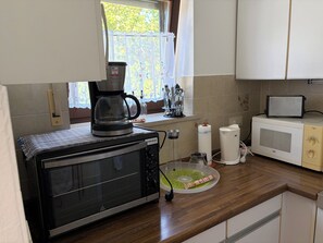A kitchen with a microwave, toaster, and coffee maker on the counter.