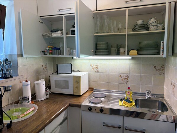 Una cocina equipada con microondas, tostadora, estufa y diversos utensilios de cocina.