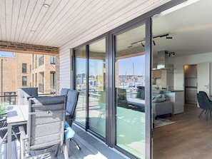Un appartement moderne doté d’un balcon, d’un coin repas et d’une cuisine.