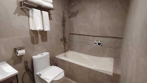 Een moderne badkamer met toilet, wastafel en ligbad.