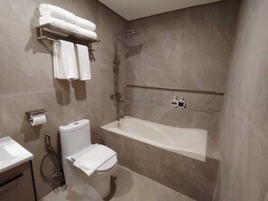 Ein modernes Badezimmer mit Toilette, Waschbecken und Badewanne.