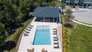 Piscina no terraço com espreguiçadeiras e um espaço coberto com varanda.