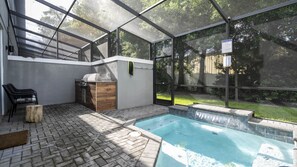 An outdoor pool area with a grill and seating. - 4BR Le Reve Pool & Themed Rooms Near Disney (Kissimmee)
