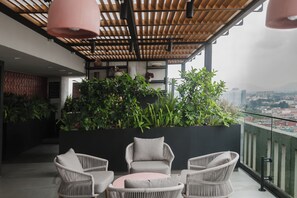 A balcony with wicker furniture and a planter with various plants. - Loft one block from the Monumento a la Revolución, between Centro Histórico and Reforma. Private balcony, rooftop with incredible views, gym, garden, and a coworking area among the shared amenities. (Tabacalera)