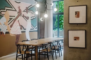 A meeting room with a long table, chairs, and framed pictures on the wall. - Loft one block from the Monumento a la Revolución, between Centro Histórico and Reforma. Private balcony, rooftop with incredible views, gym, garden, and a coworking area among the shared amenities. (Tabacalera)