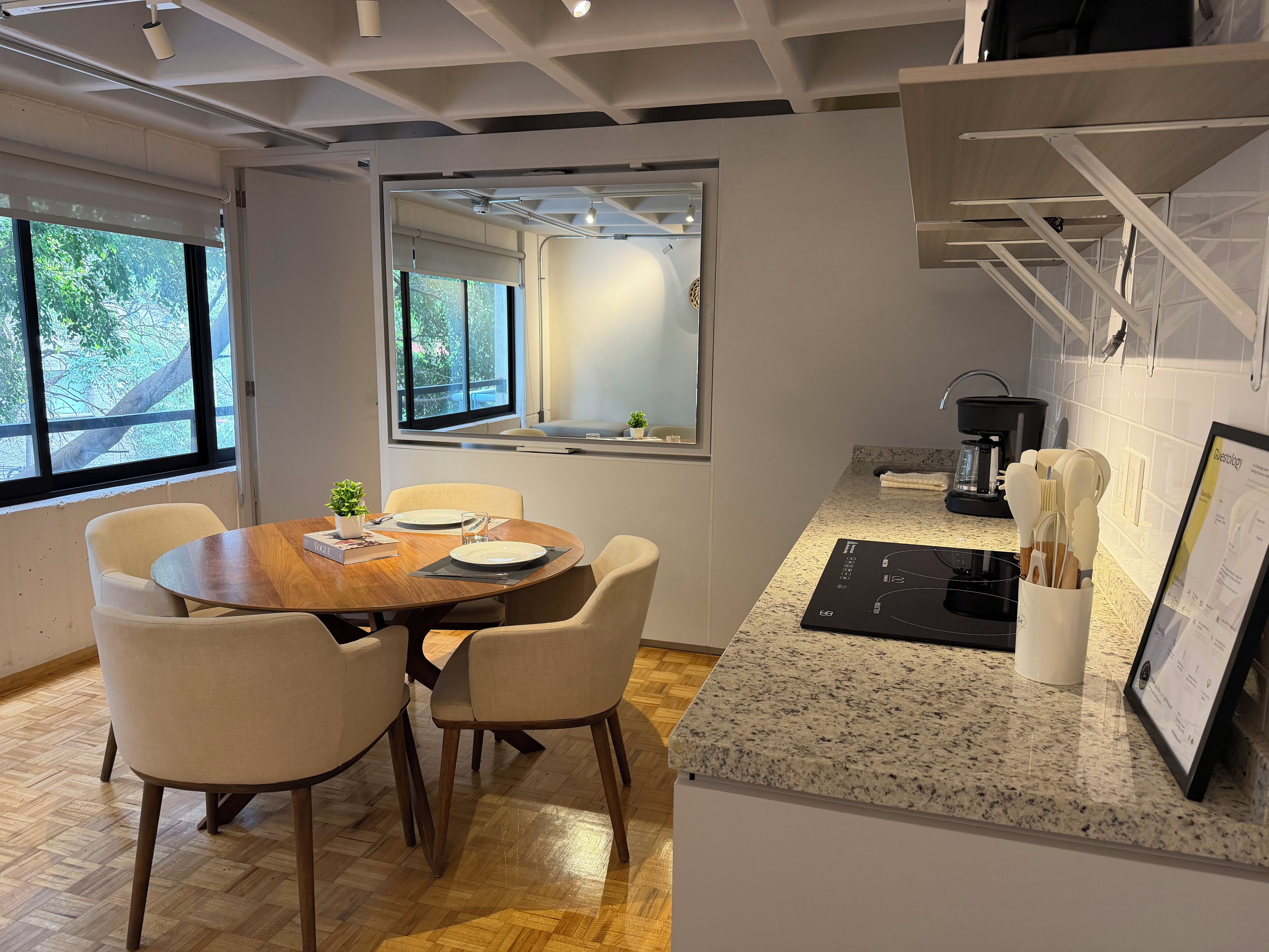 Eine moderne Küche mit Essbereich, einer Granitabdeckung und Blick durch ein Fenster.