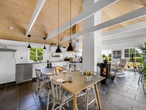 A modern kitchen with a central island, pendant lighting, and a wood-burning stove. - "Helma" - 580m to the fjord by Interhome (Ulfborg)
