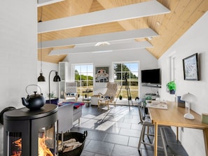 A modern interior with a fireplace, a dining area, and a large window. - "Helma" - 580m to the fjord by Interhome (Ulfborg)