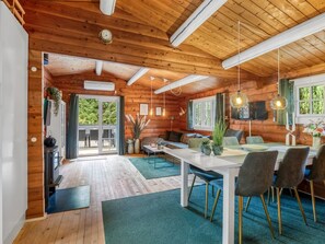 L’intérieur d’une cabane en bois comprend un coin repas, une cuisine et un espace de vie chaleureux.