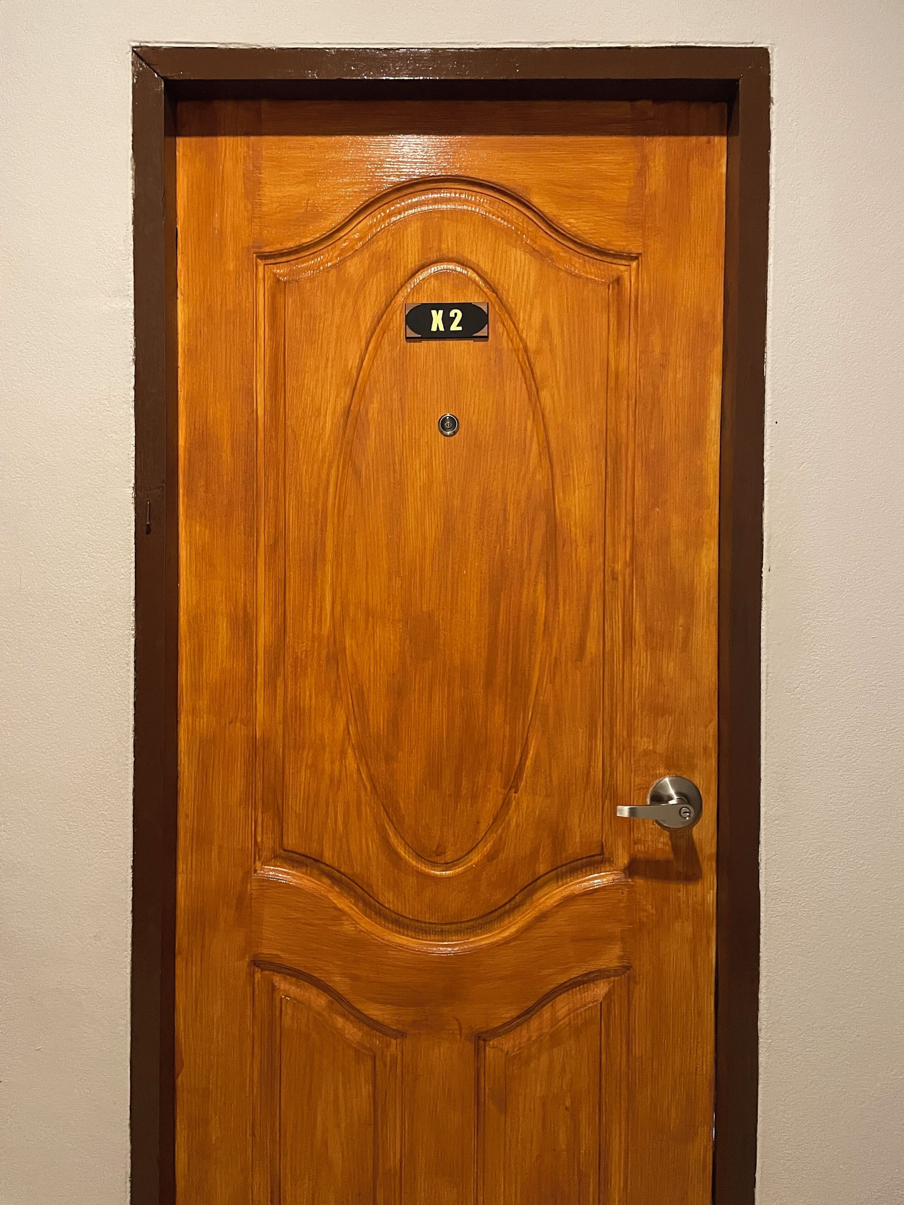 A wooden door with a metal handle and a sign above it.
