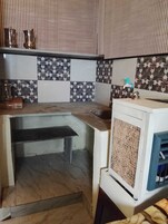 Una cocina compacta con estufa integrada, un lavamanos y una pequeña encimera.