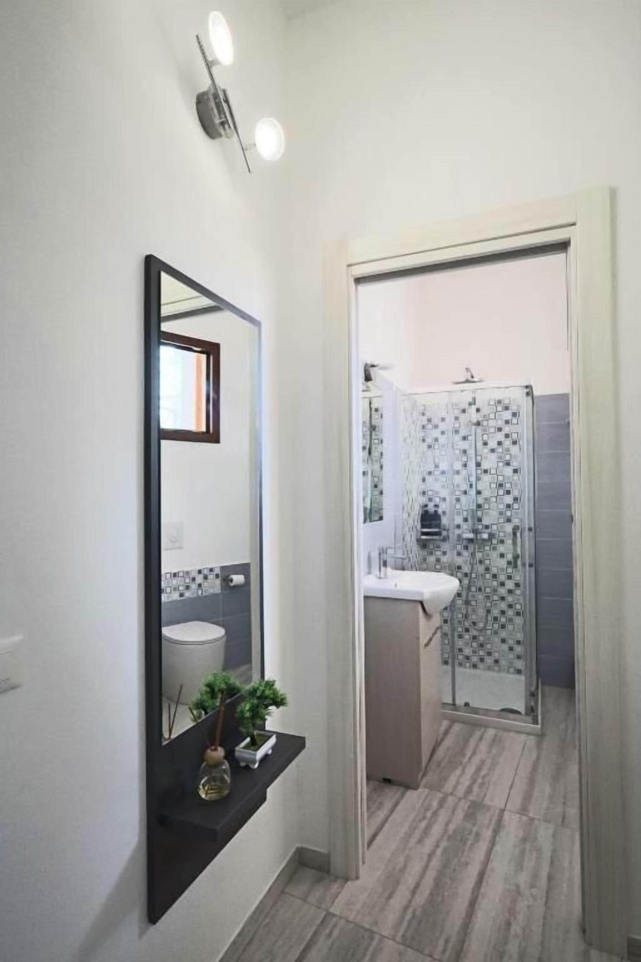 Un baño con ducha, lavabo y espejo.