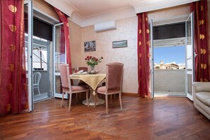 A dining area with a table, chairs, and a view through an open door. - la casetta di ili e giuly (Fiumicino)