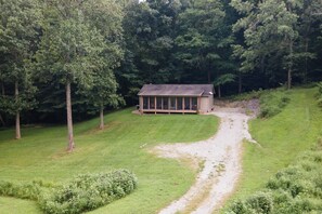 Een afgelegen chalet, omgeven door dicht bos, bereikbaar via een smal pad.