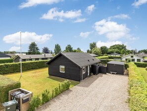 Un quartier résidentiel avec des maisons, une allée gravillonnée et une pelouse bien entretenue.