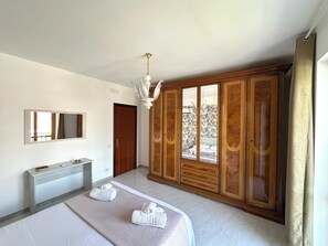A bedroom with a bed, a vanity, a wardrobe, and a chandelier. - La Pigna delle Aci Apartment (Acireale)