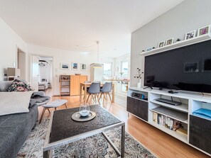 Ein modernes Wohnzimmer mit Sofa, Couchtisch und Fernsehschrank.