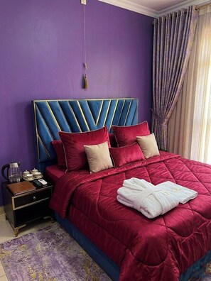 A bed with a headboard, pillows, and a red bedspread. - The Horizon Room in Kigali (Kigali)