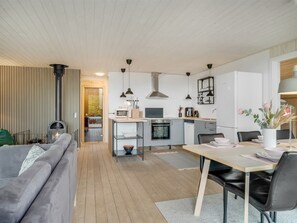 Una cocina moderna con zona de comedor, sofá y chimenea.