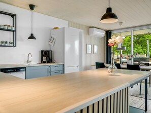 Una cocina moderna con encimera de madera, cafetera y refrigerador.