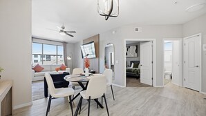 Ein modernes Wohnzimmer mit Essbereich, Deckenventilator und Blick ins Freie.
