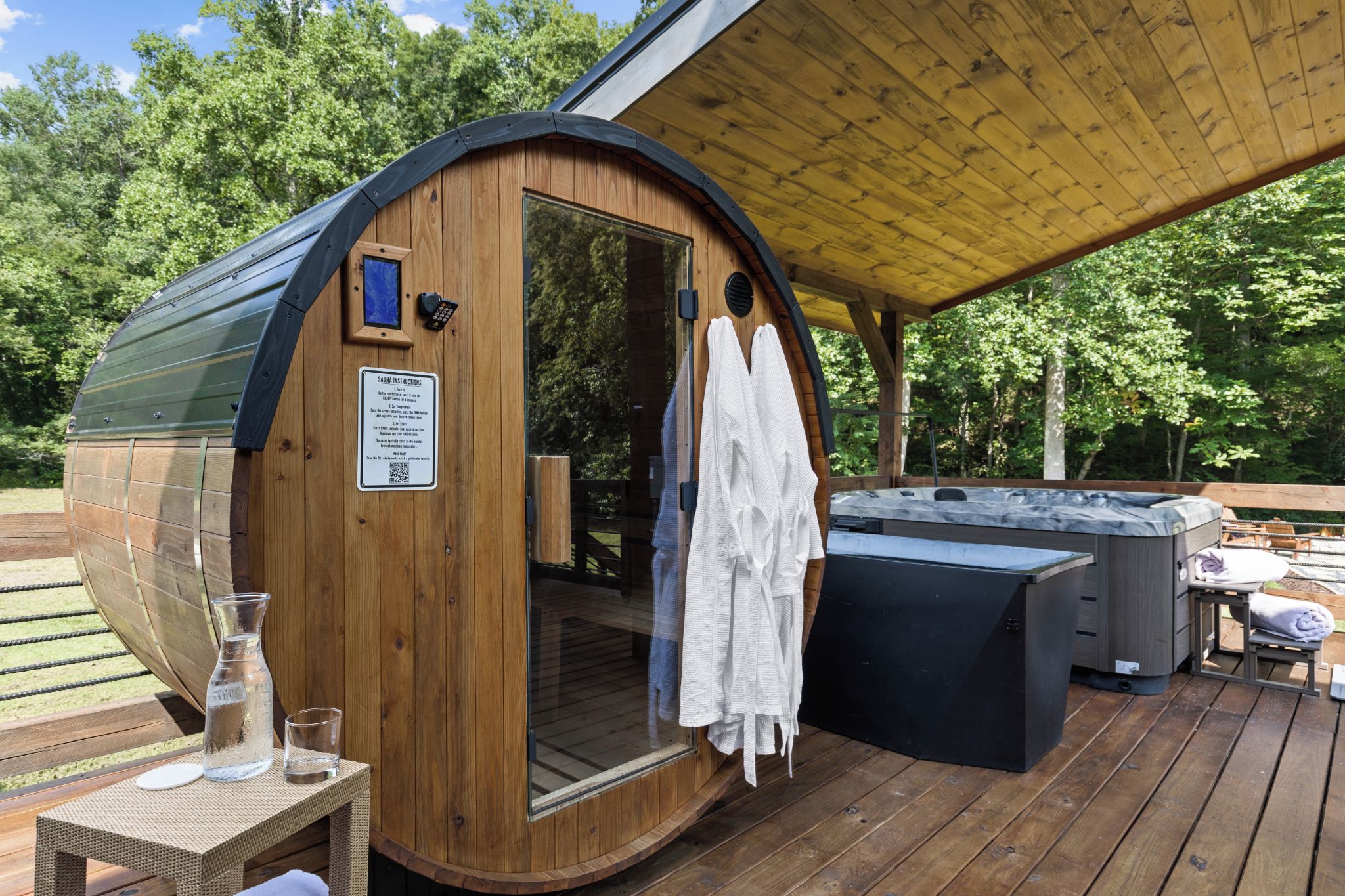 Una sauna de madera con puerta, un jacuzzi y una terraza techada.